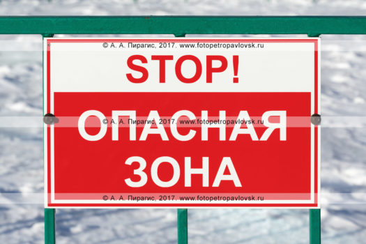 Фотография: предупреждающая табличка на заборе, надпись: "Stop! Опасная зона"