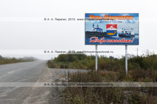 Фотографии баннера (плакат, аншлаг), установленный возле автомобильной дороги, с приветственной надписью: "Усть-Камчатск основан в 1731 году. Добро пожаловать!"