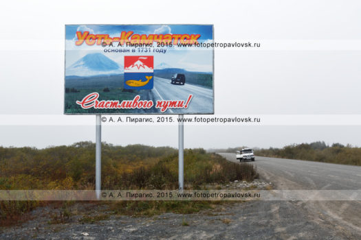 Фотография: баннер (аншлаг, плакат), установленный возле автомобильной дороги, с надписью "Усть-Камчатск основан в 1731 году. Счастливого пути!"