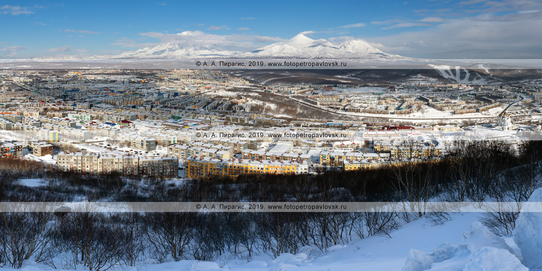 Панорамная фотография: зимний город Петропавловск-Камчатский на фоне «домашних» вулканов: Корякский вулкан, Авачинский вулкан, Козельский вулкан