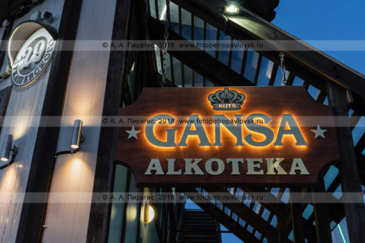 Ночная фотография деревянной вывески Gansa Alkoteka